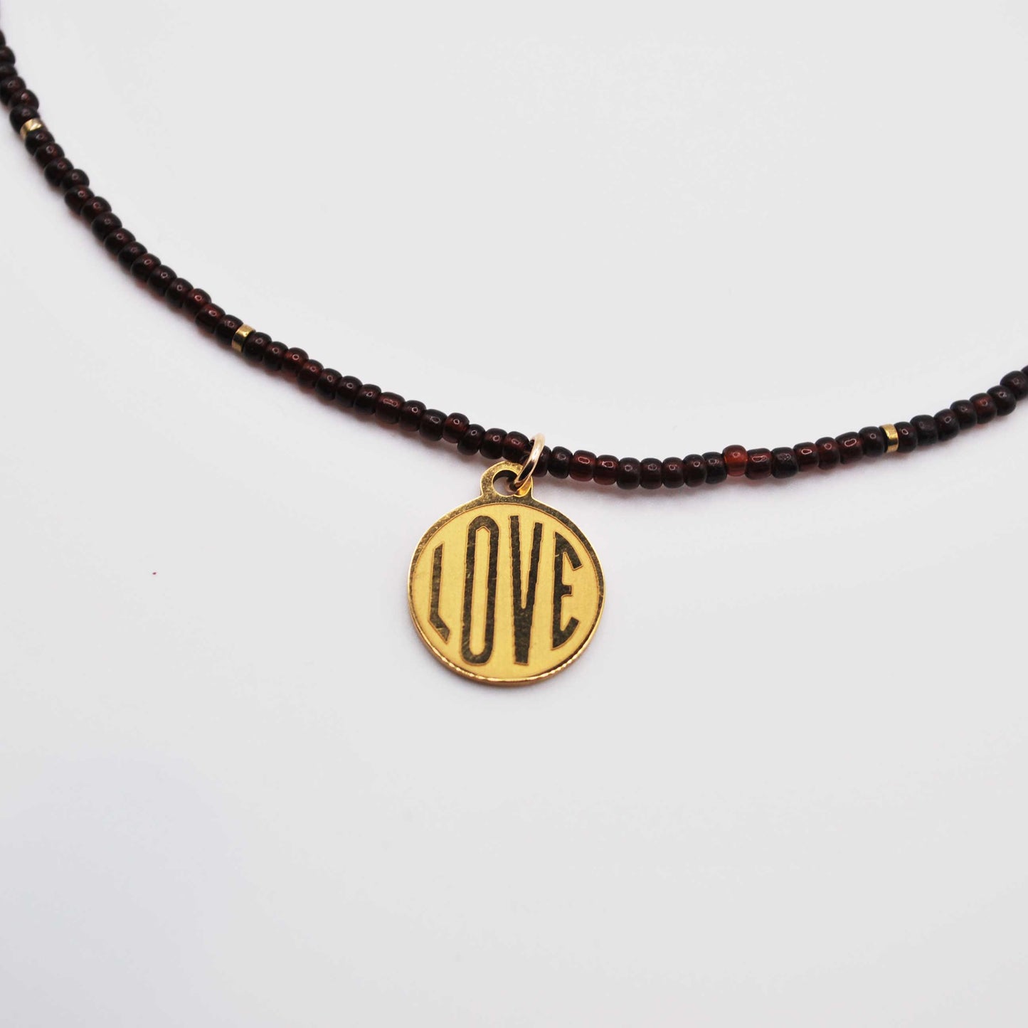 'deep tide love' garnet seed bead necklace with gold love charm