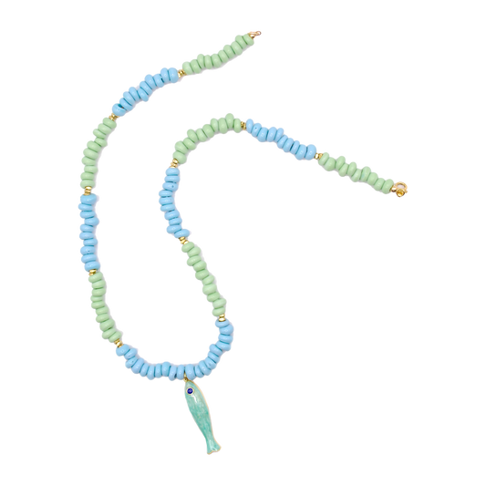 Inspired by naturally tumbled seaglass found along the shore, the 'seaglass' necklace features handcrafted green and blue beads with a green fish charm. 