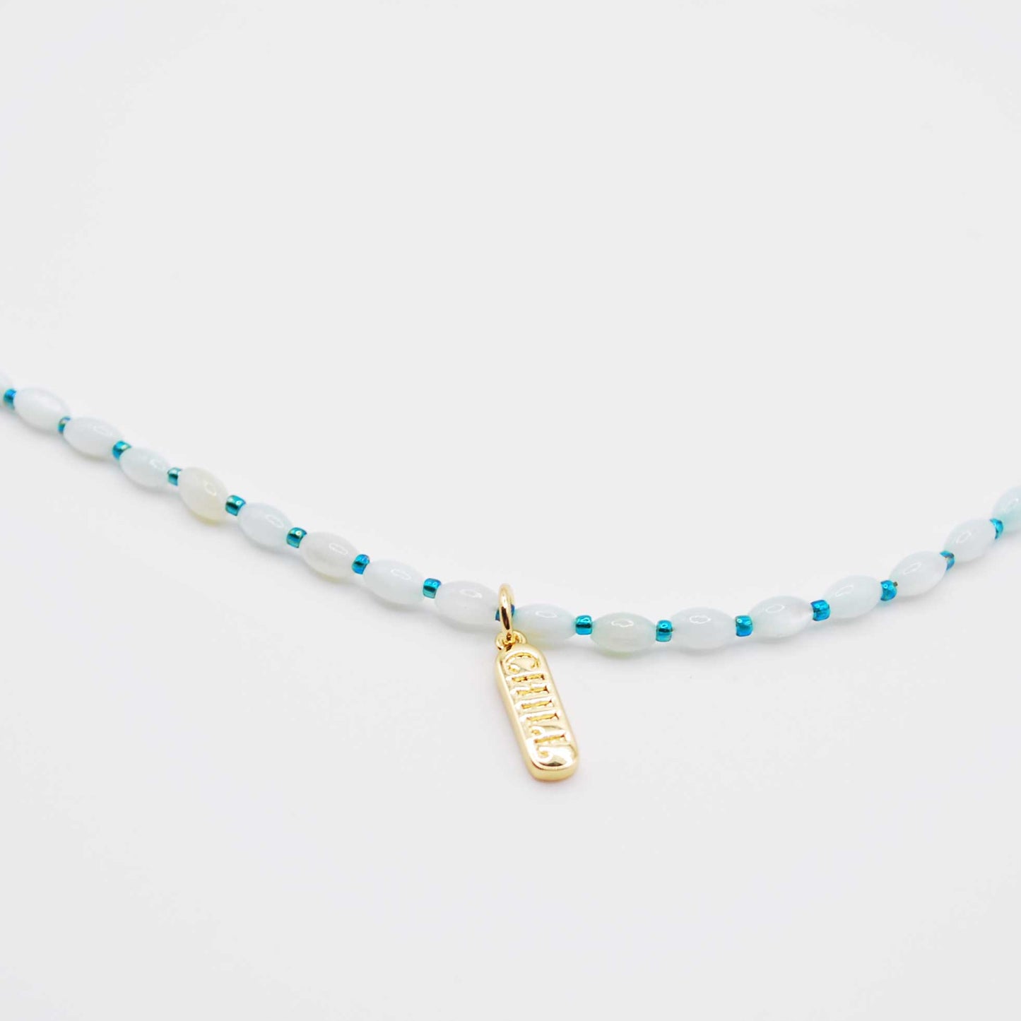 'stay chill' pearl shaped beaded necklace with 'chill' pill shaped charm