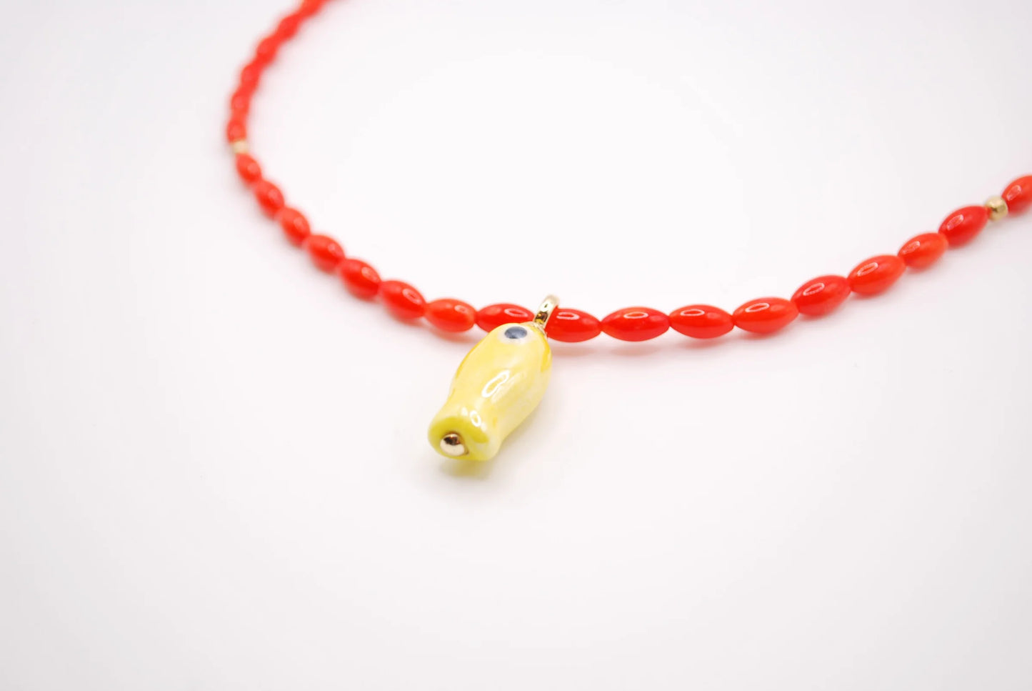 'orange tide' beaded necklace with yellow fish charm