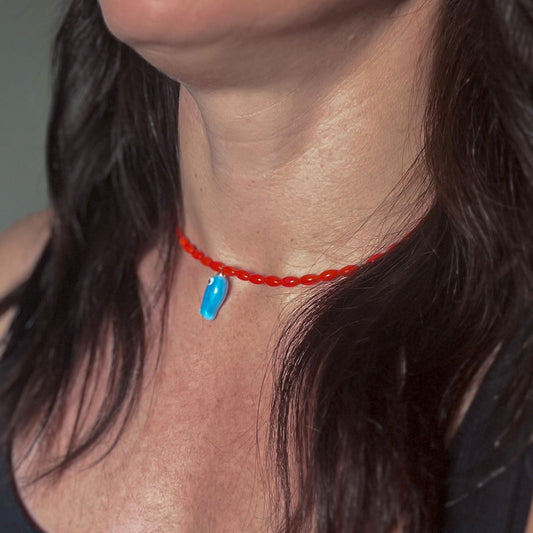 'orange tide' beaded necklace with blue fish charm
